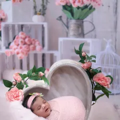 A wider view of the pink floral setup, showing the full arrangement of props including rustic white crates, a birdcage, and vases filled with pink flowers to create a beautiful scene.
