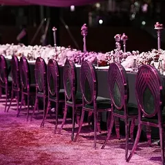 A dramatic shot of our sit-down dinner setup, with a pink filter adding a 'gullabi' (pink) mood to the elegant black chairs and floral arrangements.