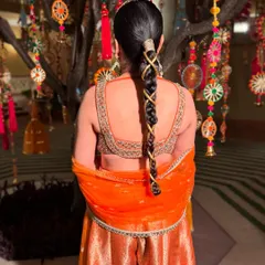 A close-up of this unique and modern braid. The criss-cross pattern with a gold thread is a creative way to elevate a simple braid for a Sufi night or Mehendi.