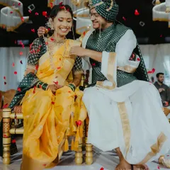 A joyful moment during a Maharashtrian wedding, with the groom tying the mangalsutra, surrounded by falling petals.