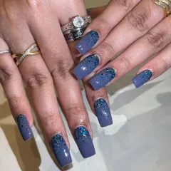 A moody blue-grey base with a cascade of blue glitter from the cuticles.
