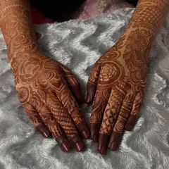 A beautiful, even stain across both hands. You can see how the intricate floral and checkerboard patterns have developed into a deep reddish-brown color.