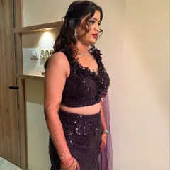 A side profile showing the complete sangeet look. The makeup is glamorous yet elegant, and her hair is styled in beautiful waves that complement her outfit.