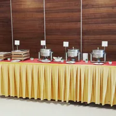 A simple and elegant buffet setup against a wood panelled wall, perfect for a corporate meeting or seminar. The focus is on clean lines and efficient service.