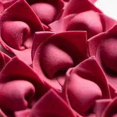 Beautiful, rose-shaped beetroot pasta. The vibrant color and unique form are highlighted in this artistic macro photograph.