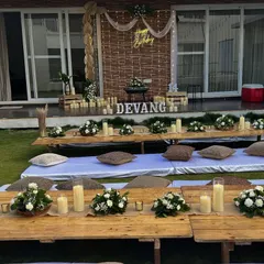 The birthday backdrop for the outdoor movie night, featuring a neon sign, candle lighting, and rustic elements.