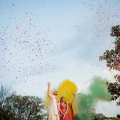 A moment of pure magic against the sky. This isn't just a photo; it's the climax of a fairytale. We use elements like colored smoke and a shower of petals to create grand, cinematic visuals that feel as epic as your love story. This is how we turn a destination into a breathtaking memory.