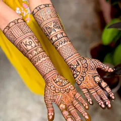 Kavitha's wedding mehendi, a beautiful example of personalized bridal art with the couple's initials "KP" and symbolic motifs like elephants and butterflies.