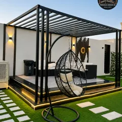 This rooftop setup shows a freestanding swing chair as a perfect complement to the main pergola lounge area. The combination of seating options makes the space versatile for both socializing and quiet relaxation.