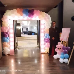 An illuminated balloon arch creates a grand entrance for any corporate gala or party. The pastel color palette and integrated lights provide a warm and inviting welcome.
