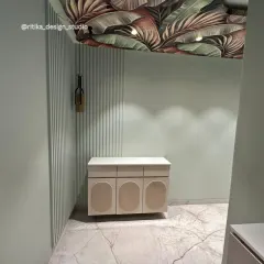 This passage is transformed into a design moment with a bold, tropical-print ceiling. The soft, pastel green walls are accented with fluted paneling and a minimalist console table, creating a chic and unexpected vignette.