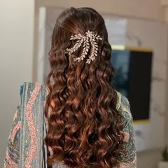 A beautiful open hairstyle with soft, romantic waves, adorned with a sparkling hair accessory for an engagement look.