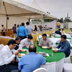 Guests enjoying a delicious meal at an outdoor corporate offsite event we catered. We provide complete seating and dining solutions to ensure comfort and convenience.