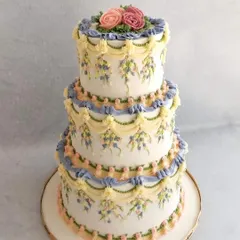 This three-tiered wedding cake is a celebration of classic English piping techniques. I love the challenge of creating these intricate, delicate buttercream drapes and patterns. It’s a timeless style that brings so much elegance to a celebration.
