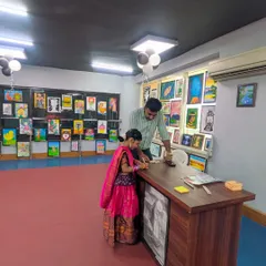 A young student, dressed for the occasion, receives guidance at the exhibition reception. This shows the interactive and personal nature of our events, where students are the stars of the show.