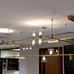 The MMDLS Chandelier offers ultimate customization. This modular system allows you to adjust the placement of individual fixtures, creating a unique, sprawling light sculpture tailored to your space.