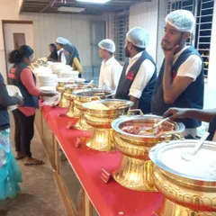 Our staff stands ready at a fully arranged buffet line at SSR Function Hall. We use traditional golden serving dishes to add a touch of class to the wedding feast, ensuring food is kept warm and served professionally.