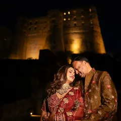 A couple celebrating their 25th anniversary shares a tender moment against the backdrop of the illuminated Alila Fort. Planning milestone events at such grand locations is one of my specialties.