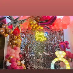Another view of the 'Bride to Be' decorations, showing how the pink and rose gold balloons complement the sparkling backdrop and light-up ring prop.