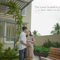 The most beautiful part of your love story is on the way. A quiet moment shared in a peaceful garden setting, with the greenery framing the couple's connection.