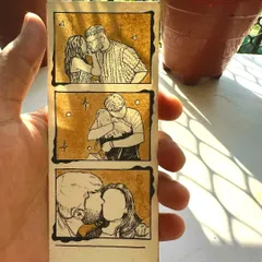 Another look at a completed photo strip, held up to catch the light. You can see the texture of the paper and the variations in the coffee stain, making each one unique.