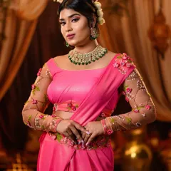 We masterfully recreate looks from every era of Bollywood. This elegant pose captures the timeless grace of Shantipriya, highlighting the custom-designed pink saree with floral embroidered sleeves and classic retro styling.