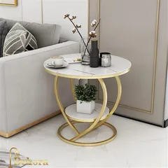 A stylish and compact two-tier end table with a heart-shaped curving metal frame in a gold finish. The dual marble-finish surfaces offer practical space for a lamp, a cup of coffee, and a small plant.