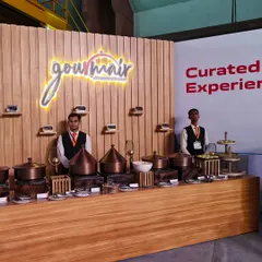 We designed and executed the 'Gourmair' food experience for the Air India X launch, held inside an active aircraft hangar. This setup, featuring elegant copper serveware, brought the sophistication of in-flight fine dining to a unique and challenging industrial venue.