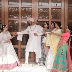 A playful moment where the bridesmaids try to hold the groom back from his bride. These fun, candid shots with the wedding party are always a hit.