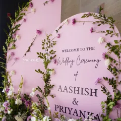 A close-up of a personalized welcome sign for a wedding ceremony, with delicate floral decorations.