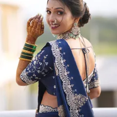 A modern take on the Maharashtrian bride. The stunning navy blue Nauvari saree is complemented by a soft glam makeup look, a chic bun, and elegant silver-toned jewellery.