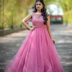 A full-length shot of a model in a beautiful pink ball gown, looking like a modern-day princess.