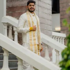 A confident portrait of a groom in traditional South Indian attire. We captured him on a grand staircase, creating a clean and classic look.