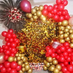 A glamorous balloon decoration featuring a gold sequin wall framed by an arch of red and gold balloons, perfect for birthdays, anniversaries, or parties.