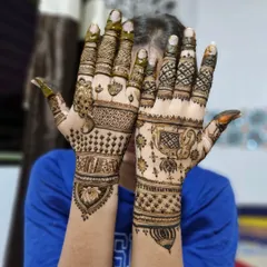 A playful pose showing the back of the hands, which feature simpler, elegant versions of the traditional motifs on the palms.
