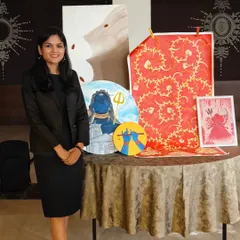 Just me, proudly standing with a collection of my paintings. This display includes a variety of my work, from a textured abstract to spiritual pieces featuring Shiva and Maa Kali.