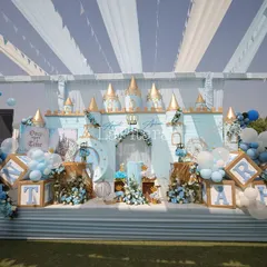 A wide view of the outdoor prince-themed party setup, showcasing the grand stage with a castle backdrop and personalized letter blocks. The entire area is designed to feel like a royal courtyard, ready for a day of celebration.