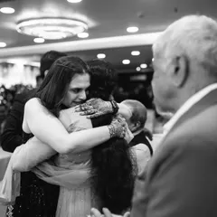 An emotional embrace between the bride and a loved one, captured in a poignant black and white frame that emphasizes the feeling of the moment.