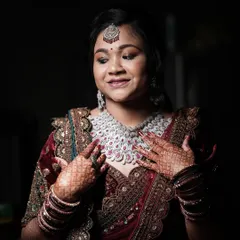 A candid moment of the bride admiring her diamond necklace and intricate henna design. I focus on these small, happy details during the getting-ready process.
