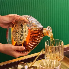 A human element adds a touch of warmth and action to a product shot. Here, we see the elegant bottle design of Monarch Brandy in use, making the image more engaging and dynamic for the campaign.