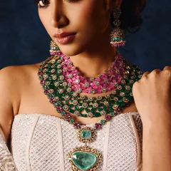 This shot showcases a magnificent multi-layered necklace. The lighting is carefully controlled to highlight the vibrant colors of the emeralds and rubies without losing detail in the intricate design.