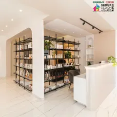 The reception area of the salon welcomes clients with a clean, minimalist aesthetic. A fluted-panel desk and open-shelving units for product display create a professional and organized first impression.