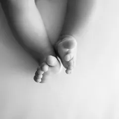 A simple, artistic shot of a baby's feet in black and white. This minimalist approach highlights their tiny, perfect form.