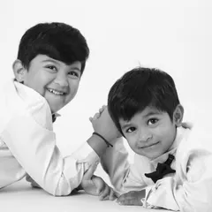 A classic black and white portrait of two brothers, capturing a moment of connection and affection between them.