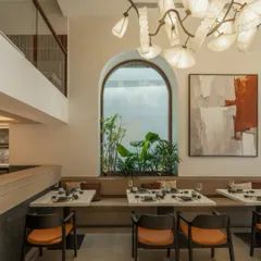A view from the mezzanine level shows the relationship between the two floors, connected by the open space and the consistent, calming design language.