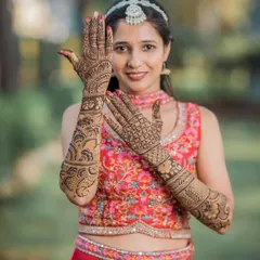 A clear and detailed shot of the bride's full bridal henna, showcasing the intricate patterns on her hands and arms.