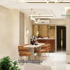 An open-concept design connecting the dining and kitchen areas. The warm, earthy tones of the dining chairs and kitchen bar create a cohesive flow, while modern pendant lights define each space.