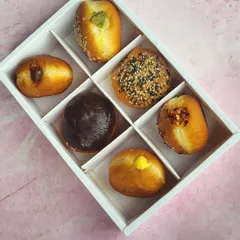 Here’s another look at my assorted bombolini box, perfect for gifting. Each one is filled with a different flavor, offering a delightful surprise in every bite, from rich chocolate to creamy custard and savory pesto.
