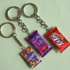 A set of three popular chocolate keychains: Gems, Dairy Milk Silk, and KitKat.