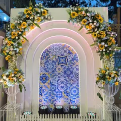 For a unique Haldi, I designed this backdrop combining Moroccan blue tiles with bright yellow sunflowers. The arched panels create a beautiful contrast and a vibrant setting.